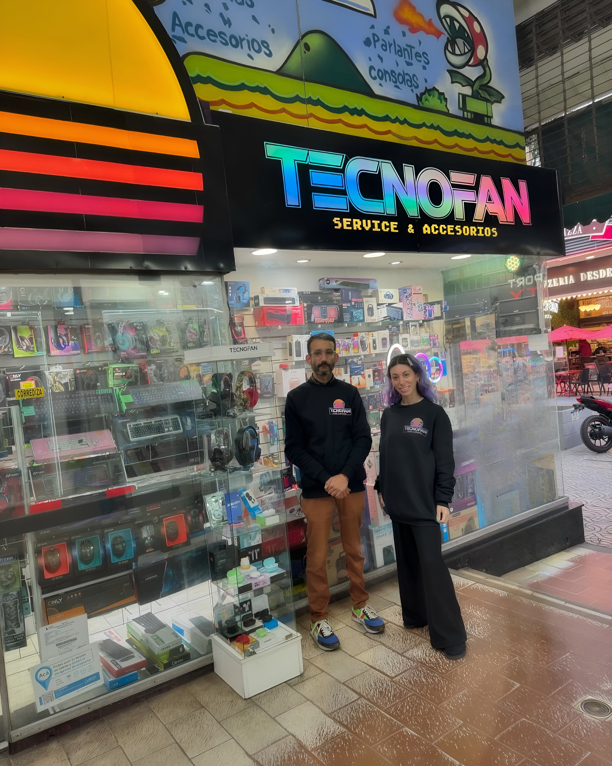 El equipo de Tecnofan frente al local, con la vidriera llena de auriculares, teclados y parlantes