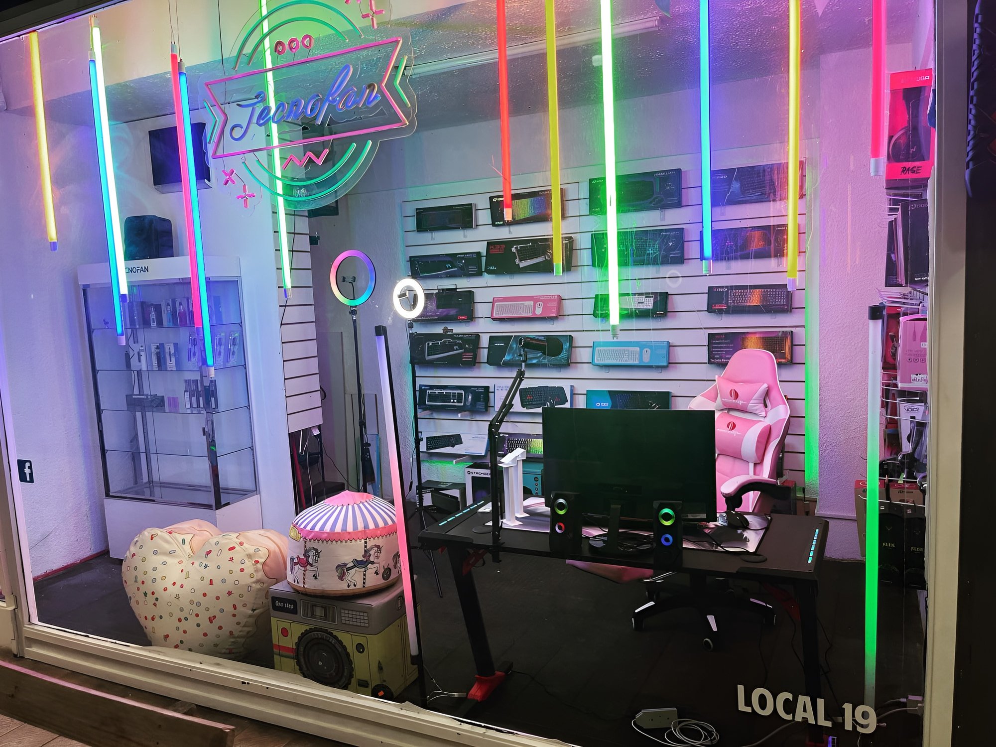 Vidriera del showroom en el Local 19 de la galería, con luces de colores y el cartel de Tecnofan
